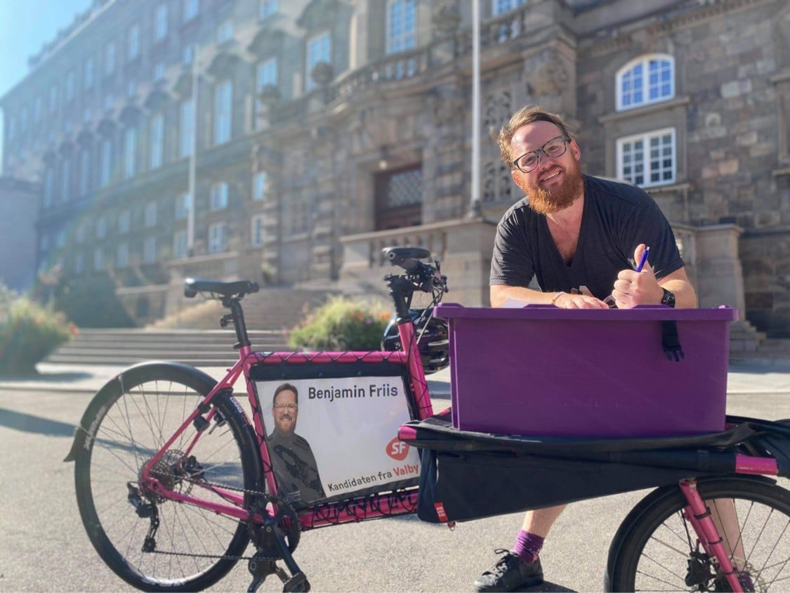 Billede af Benjamin Friis sammen med sin lyserøde ladcykel