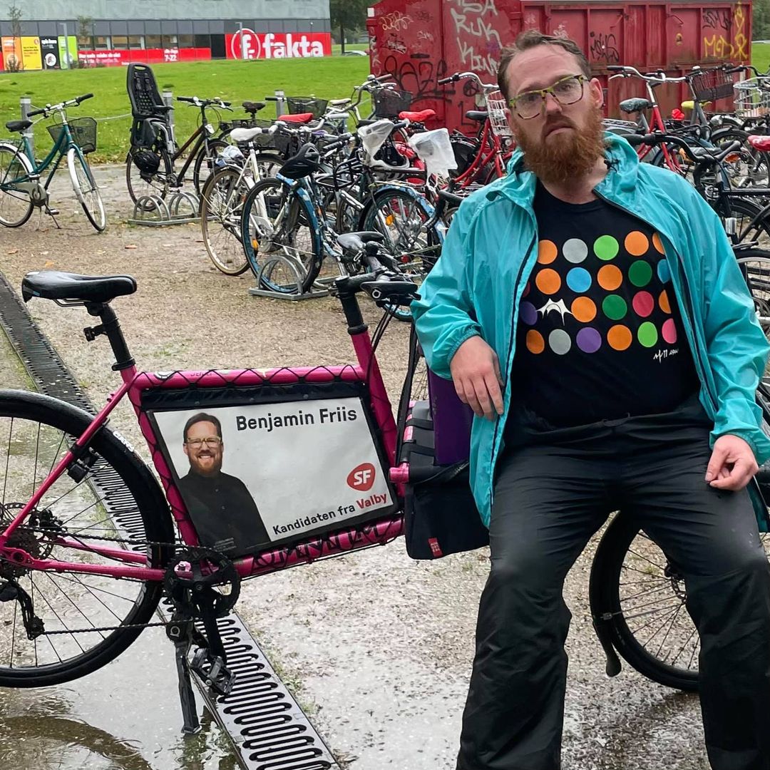 En træt og våd Benjamin Friis der får et hvil på ladet af sin cykel
